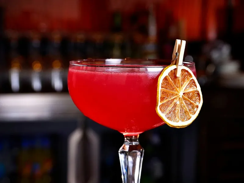 Red cosmopolitan in a coupe with a dried orange wheel